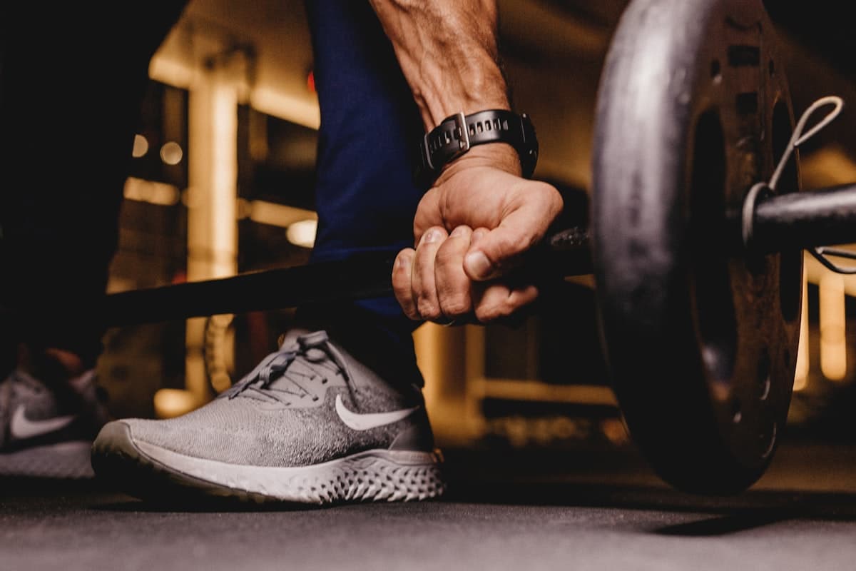 Close-up of a hand gripping a loaded barbell at the start of a lift