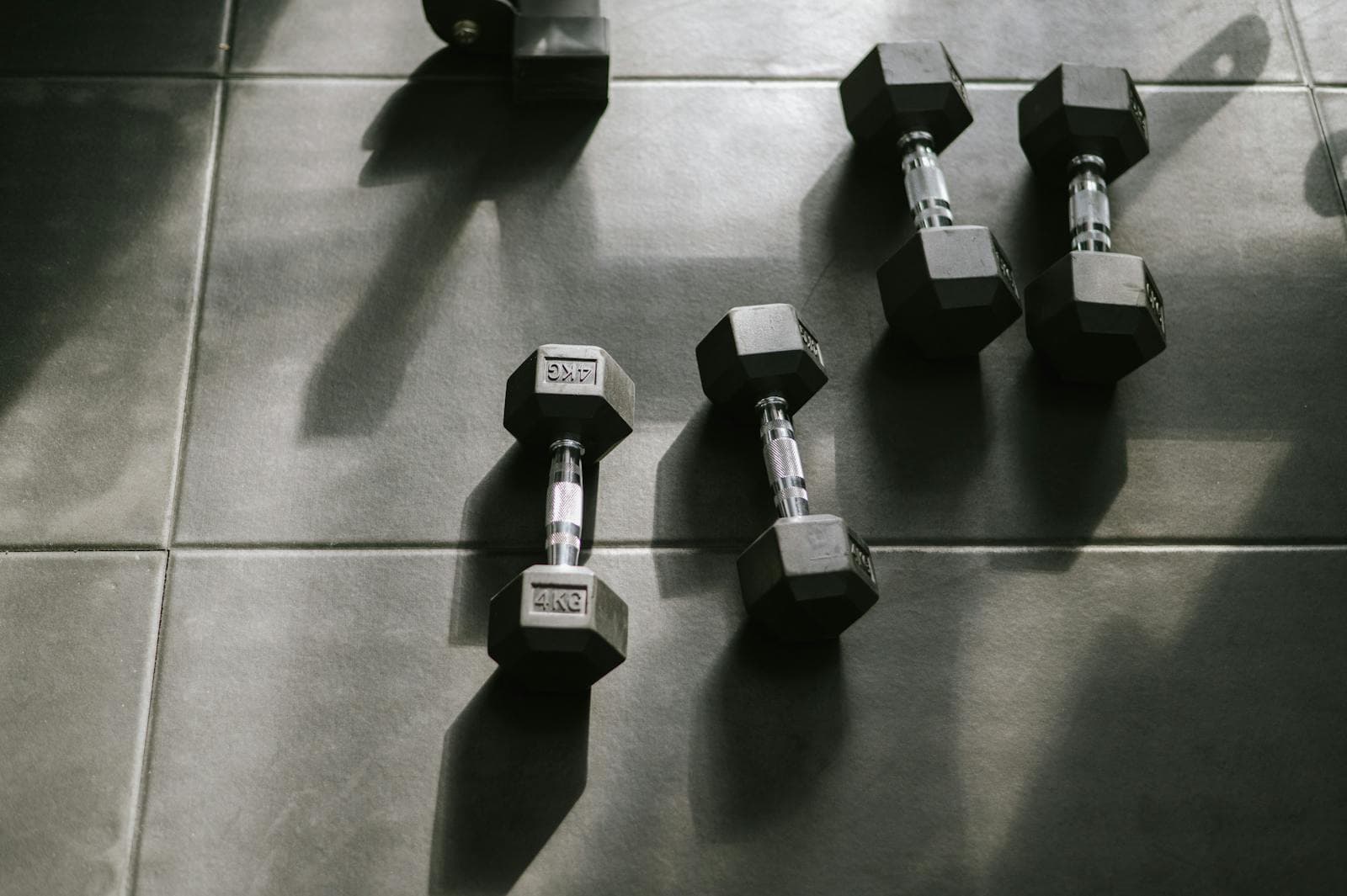 4kg hex dumbbells lying on a gym floor in natural light